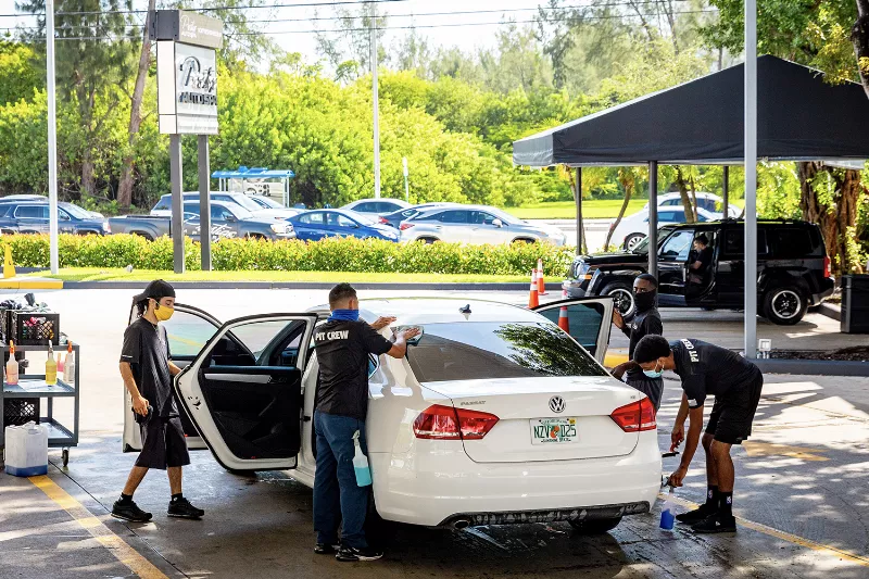 Applying ceramic coating to a car's exterior for long-lasting protection in Miami.