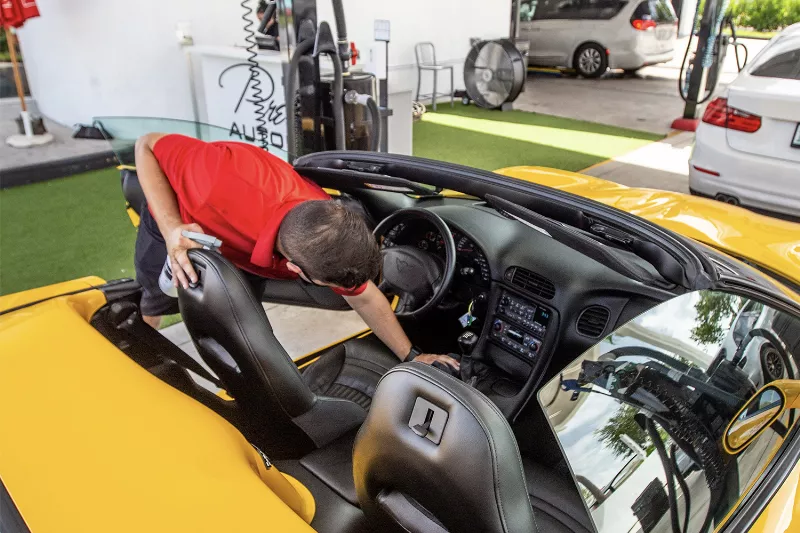 Detailing the interior of a yellow Corvette, including leather and upholstery cleaning at Prestige Auto Spa in Miami.