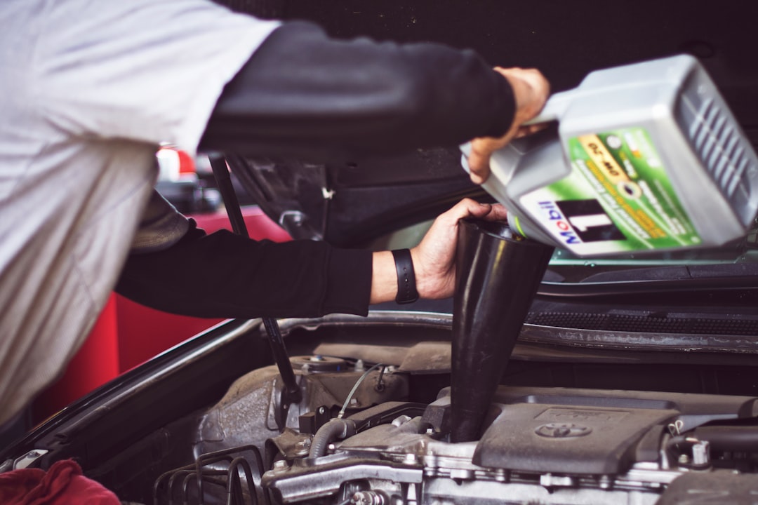 Mechanic performing engine oil change on a car