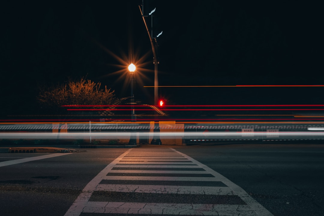 Car light streaks across a road at night