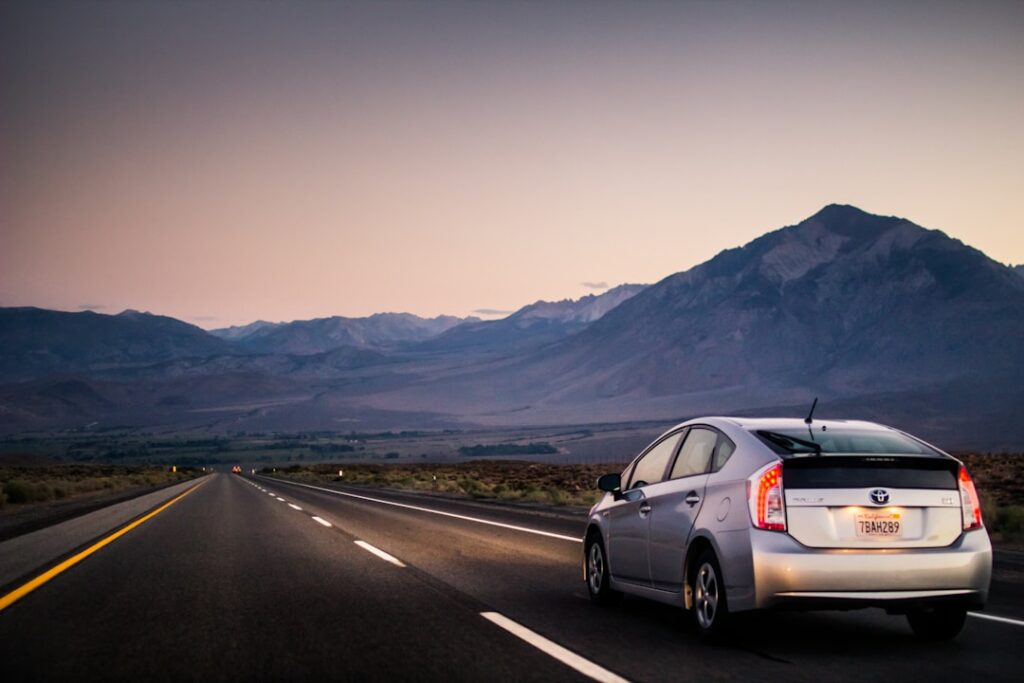 Vehicle driving through empty road at sunrise