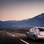 Vehicle driving through empty road at sunrise
