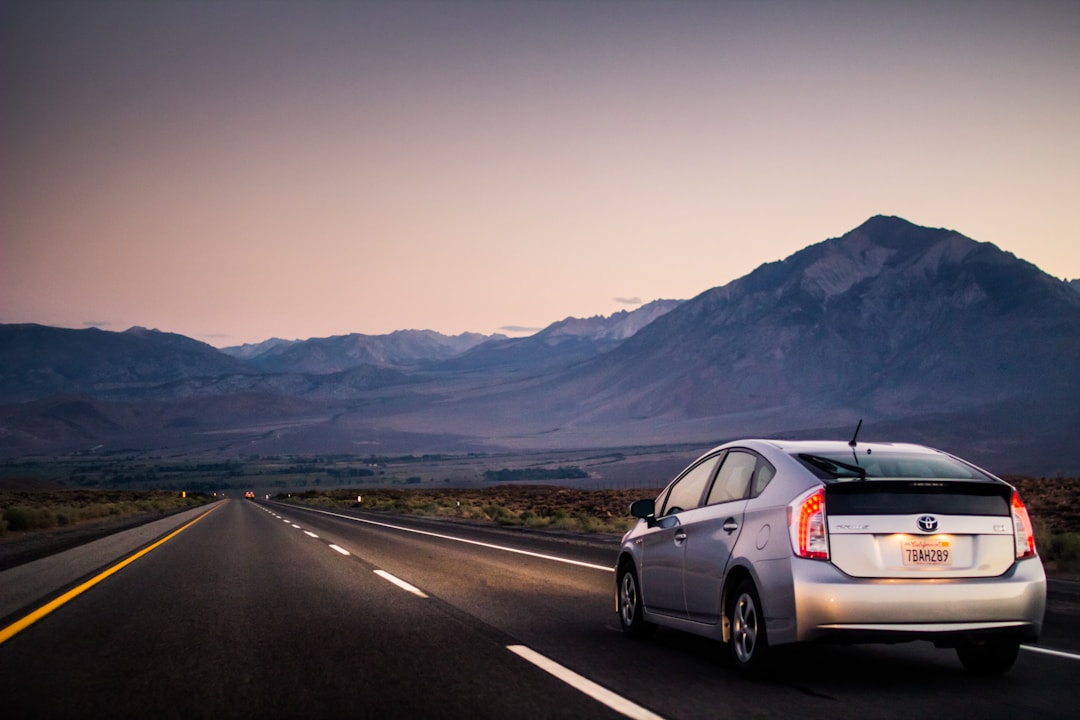 Vehicle driving through empty road at sunrise