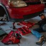 Mechanic working on car suspension in garage