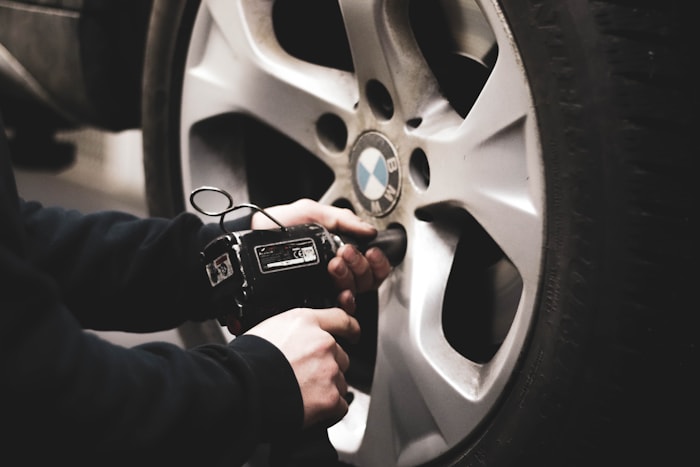 Mechanic inspecting car tire and wheel